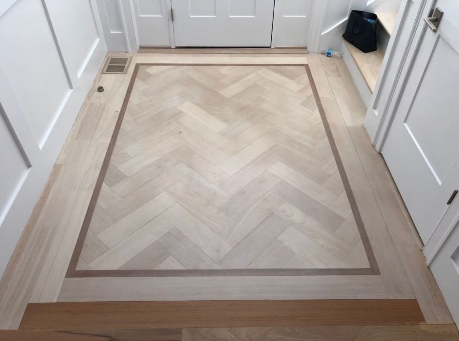 Herringbone hardwood inlay with a contrasting border, installed by W.L Home Improvement