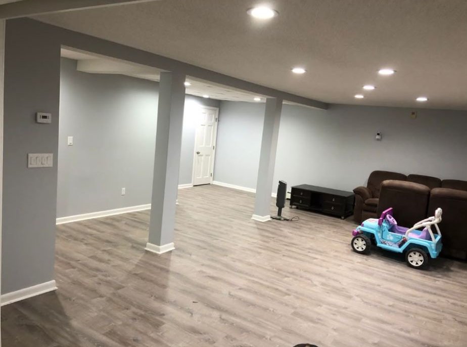 Gray vinyl plank across an open basement